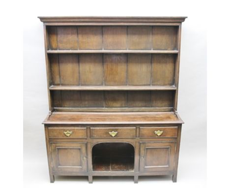 A GEORGIAN DESIGN OAK DRESSER with open shelf plate rack back, the base fitted three drawers with brass handles, over central