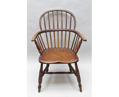 A 19TH CENTURY PROVINCIAL COMB BACK ARMCHAIR, with shaped elm seat, on turned supports and 'H' shaped stretcher 