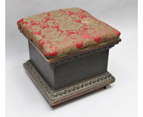 A 19TH CENTURY CARVED SQUARE BOX OTTOMAN with lift-up pad top, twin bands of architectural carving, supported on four recesse