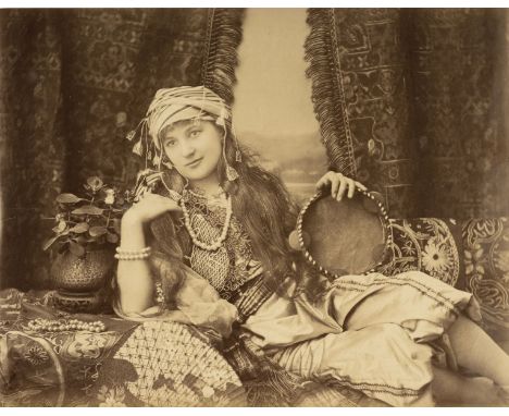 * Turkey. Portrait of a Turkish woman reclining on a divan with tambourine in hand, by Hippolyte Arnoux, c. 1870, albumen pri