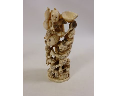 Meiji period Japanese Ivory Okimono carving of a Fisherman holding a fish and surrounded by children. Signed on base. H. 19cm