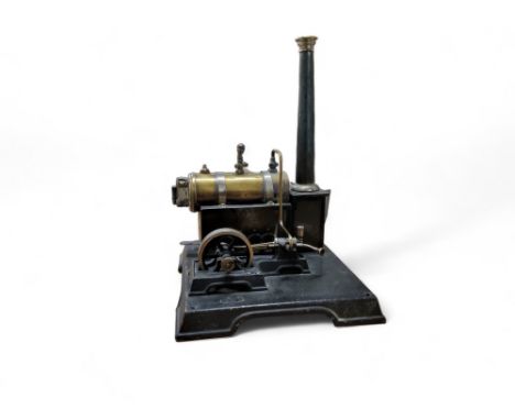 A Marklin brass and tin plate steam engine, with a single fly wheel, pressure gauge and chimney, on a metal square base, 22cm
