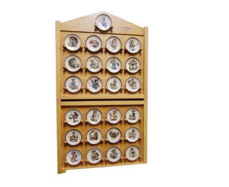 A set of twenty five Goebel miniature plates, designed by M I Hummel, 8cm high, printed marks, display case 