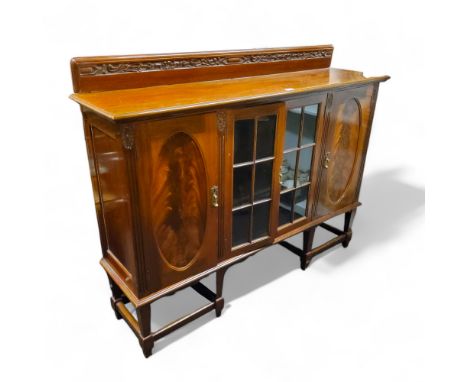 A Victorian mahogany display cabinet, glazed doors flanked by oval panel doors, tapered legs, 120cm high, 153cm wide, c.1890 