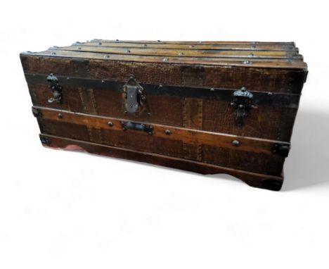 An early 20th century wood and pressed metal faux crocodile skin bound travel trunk 