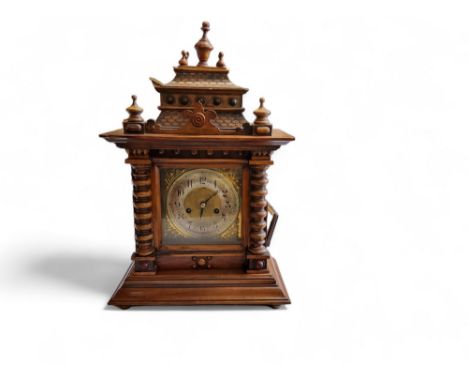 A late 19th century German mantel clock, Arabic numerals, twin winding holes, striking on a gong, the case with stepped archi