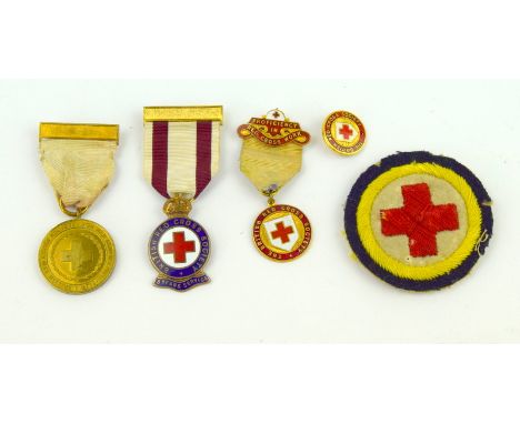 A WW1 British Red Cross Society War Medal with two BRCS enamel medals a BRCS badge and an embroidered Red Cross cloth badge