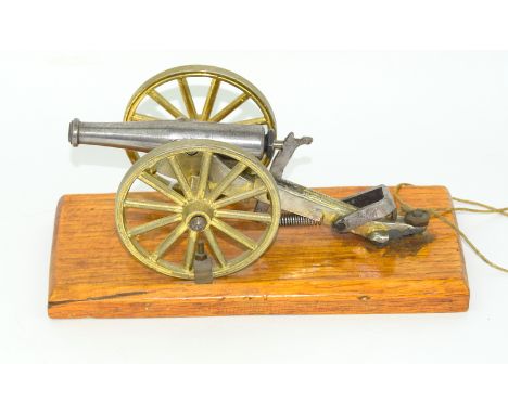 An unusual Breach Loading fully working desk top model cannon secured to a wooden base. Barrel length 10cms with the base bei