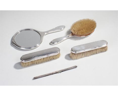 Silver vanity set, to include three brushes a comb bar and a mirror, (5)