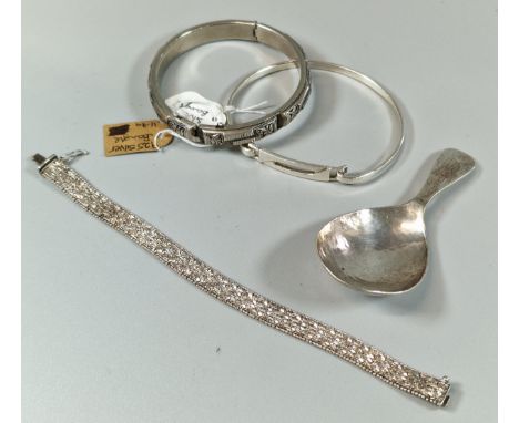 Two silver bangles, together with a silver herringbone bracelet and an unusual white metal beaten tea caddy spoon, maker's ma