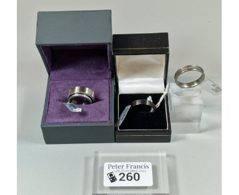 Three modernist design rings to include: Titanium ring of ribbed form. In ring box. Size T. An unusual diamond and stainless 