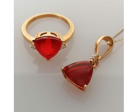 A trilliant-cut ruby ring with diamond decoration by Iliana, on a yellow gold claw setting, each side of the stone 10mm, size