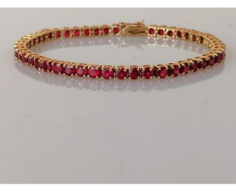 An 18ct yellow gold and ruby tennis or line bracelet in a claw setting, box clasp, 18 cm, each round-cut stone approximately 