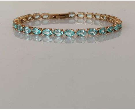 An aquamarine line or tennis bracelet in a yellow gold claw setting, each stone approximately 5 x 4mm, box clasp, 18 cm, hall