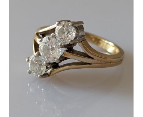 A three-stone diamond ring in a gold claw setting, centrally set with one old European-cut diamond measuring 5.91mm x 5.85mm 