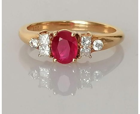 An 18ct yellow gold ruby and diamond ring by Iliana in a claw setting, the faceted oval ruby 6 x 5mm flanked, by two square-c