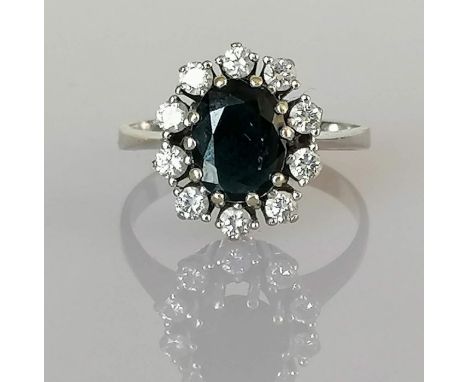 An oval sapphire and diamond cluster ring on a white gold setting, the sapphire  9 x 6mm, approximately 1.00 carats, total di