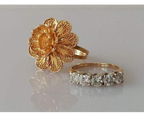 A yellow gold filigree flower ring on a split shank, size O, central stone missing, Arabic mark, tests for 20ct gold, 6.3g an