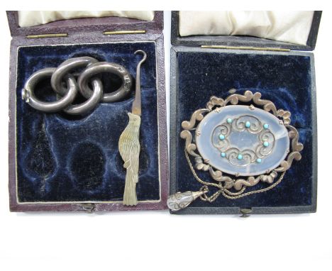 A Large XIX Century Brooch, the oval panel with applied scroll detail and cabachon highlights, with chain drop below (damages