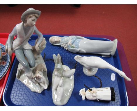 A Lladro Model of a Seated Boy with Dog, a Lladro girl with flowers, Lladro goose, Nao bird group and a Royal Worcester nun c