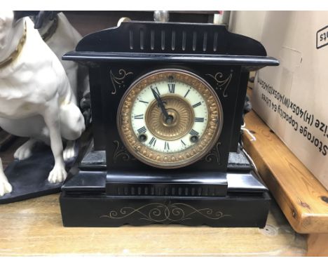 A Victorian black mantel clock the dial with Roman numerals