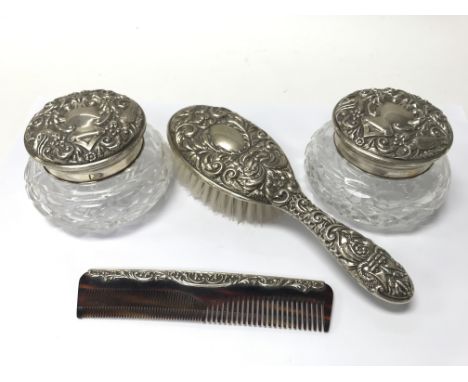 A pair of silver topped tidy jars, a brush and comb.