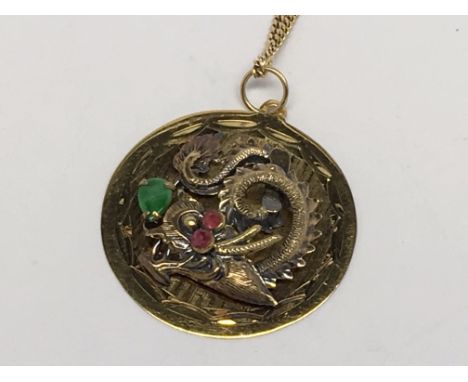 A 14ct gold ruby and jade dragon pendant on a diamond cut gold curb chain
