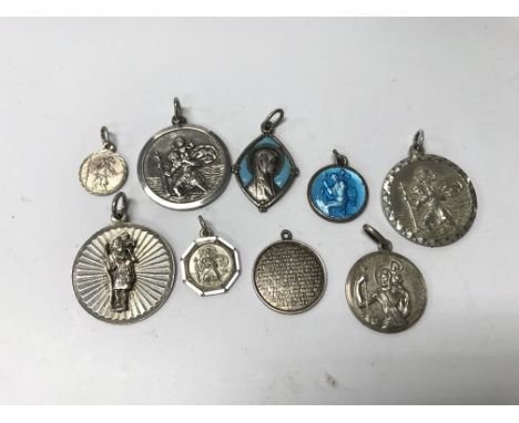 A collection of 9 silver and enamel St. Christopher pendants. Weight approx 30g