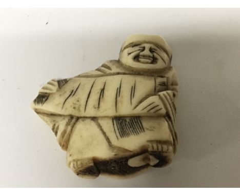 A carved Japanese late 19th Century Netsuke. In the form of a male figure.