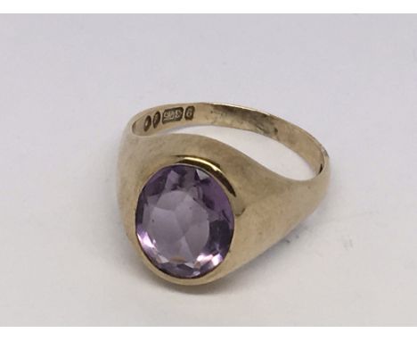 An oval amethyst set in a 9ct gold rub over set ring.  Size R