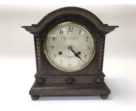 An oak mantel clock by Camerer Cuss &amp; Co. of London together with a small barometer.