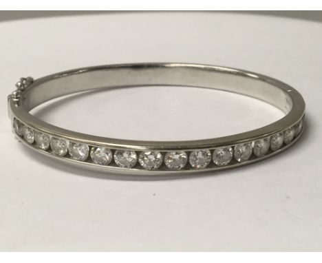 A diamond set oval hinged 18 ct bangle consisting of seventeen round brilliant cut diamonds , total diamond weight 4.04 ct co