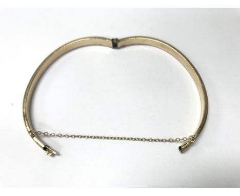 A 9ct gold metal core bangle.