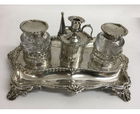 A fine quality Victorian silver inkwell stand of shaped form with two pierced holders containing glass bottles and engraved o