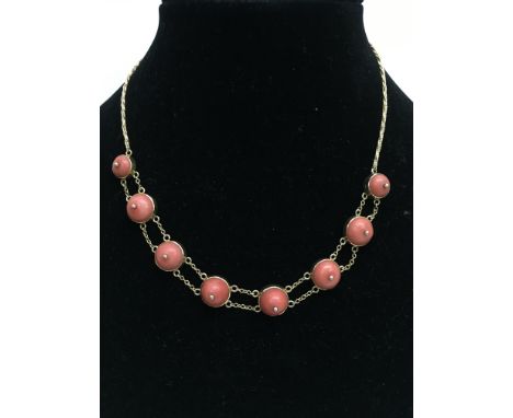 An 18ct gold chain necklace inset with coral cabochon stones in distinctive style.