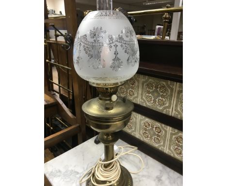 A converted brass oil lamp with engraved shade and glass funnel