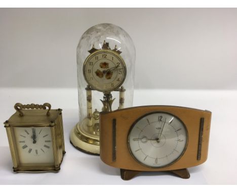 A brass anniversary clock under a glass dome, an 8 day carriage clock and a mantel clock