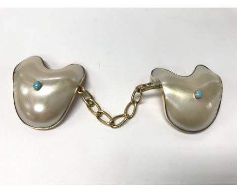 An antique mother of pearl and turquoise cloak clasp.