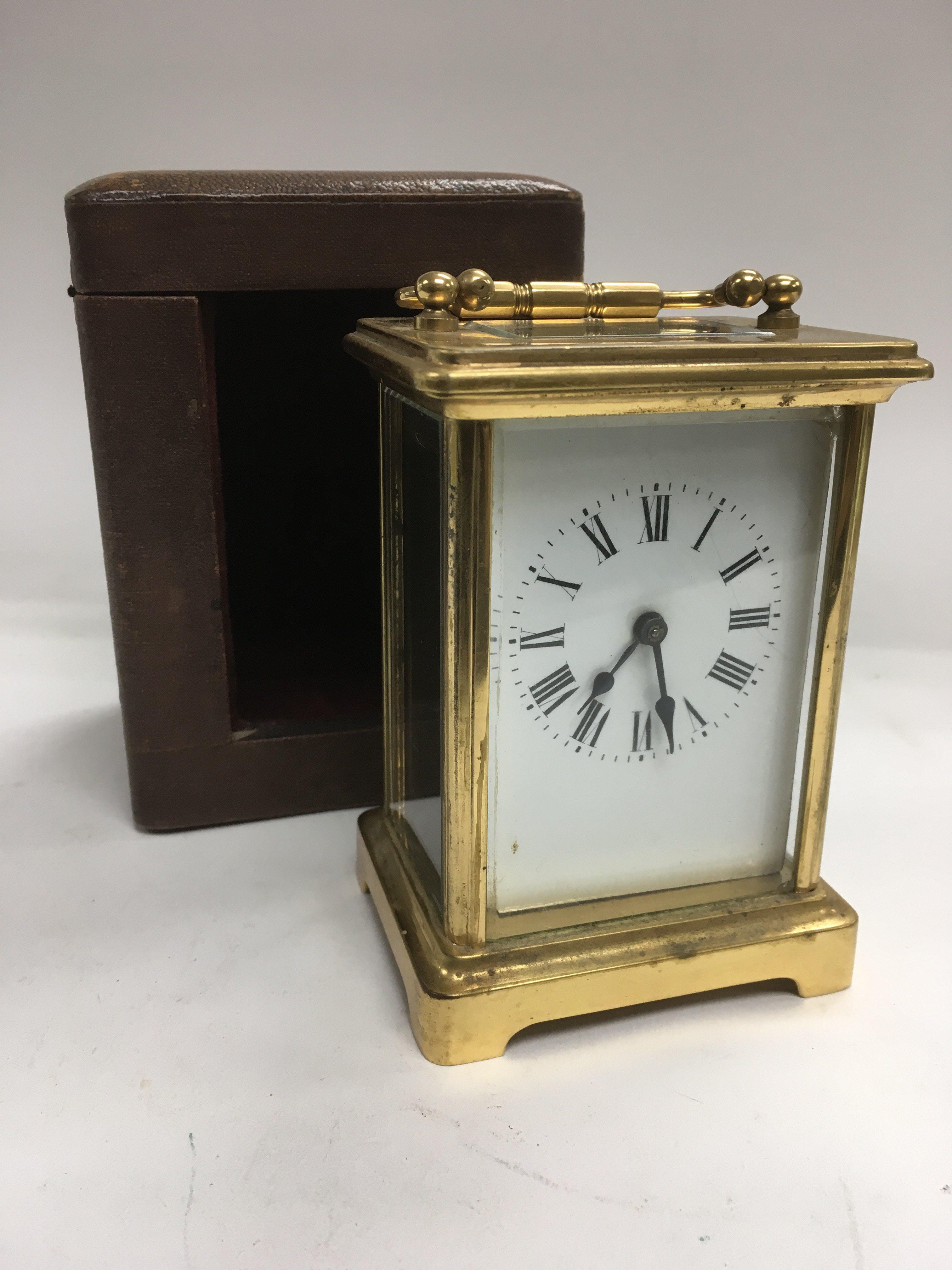 A brass carriage clock with leather outer travelling case.