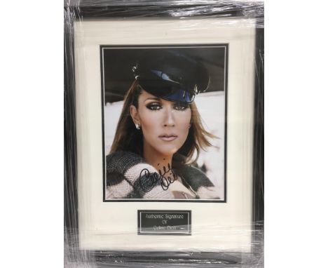 A framed and glazed photograph of Celine Dion with attributed signature, approx 35.5cm x 44.5cm.