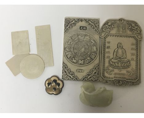A Chinese jade carving in the form of a duck a Japanese Satsuma button mother of pearl counters, and two white metal plaques.
