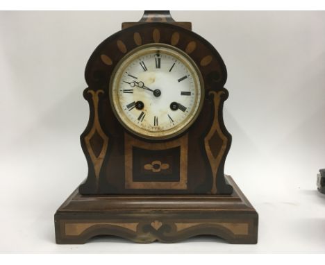 A mahogany inland mantle clock the circular dial with Roman numerals