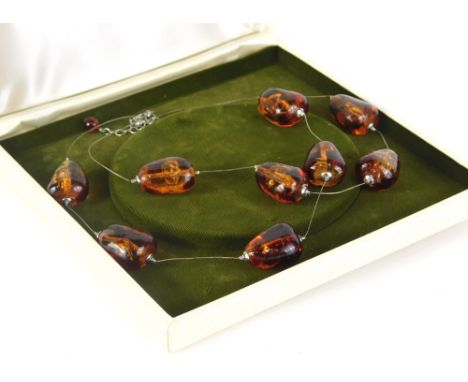 A modern graduated amber necklace, of two rows, one with four beads, one with five, of shaped form, 2.5cm high, on a wirework