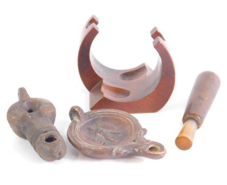 A terracotta oil lamp, probably Roman, raised with centurion, 11cm wide, a phallus shaped oil lamp, and a later turned wooden