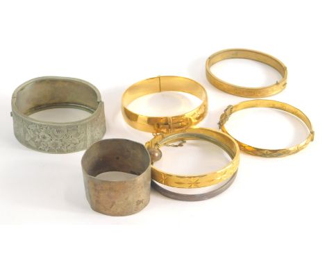 Eight various bangles, comprising a silver half hinged bangle with engraved floral design and a group of plated bangles. (8)