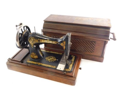 An early 20thC Singer manual sewing machine in walnut case, 32cm high.
