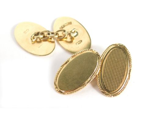 A pair of 9ct gold oval engine turned cuff links, each with a rope twist and fan design border, one half plain the other with