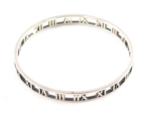An Atlas Tiffany bangle, set with Roman numerals, partially pierced, marked Tiffany &amp; Co AG925, 7cm diameter.