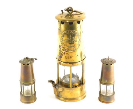 Two miniature brass miners lamps, and another M &amp; Q Eccles type 6 safety lamp, 23cm high.