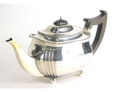 A George V silver teapot, of cape form, on orb feet with thumb mould ebonised handle and compressed knop, Birmingham 1921, 15